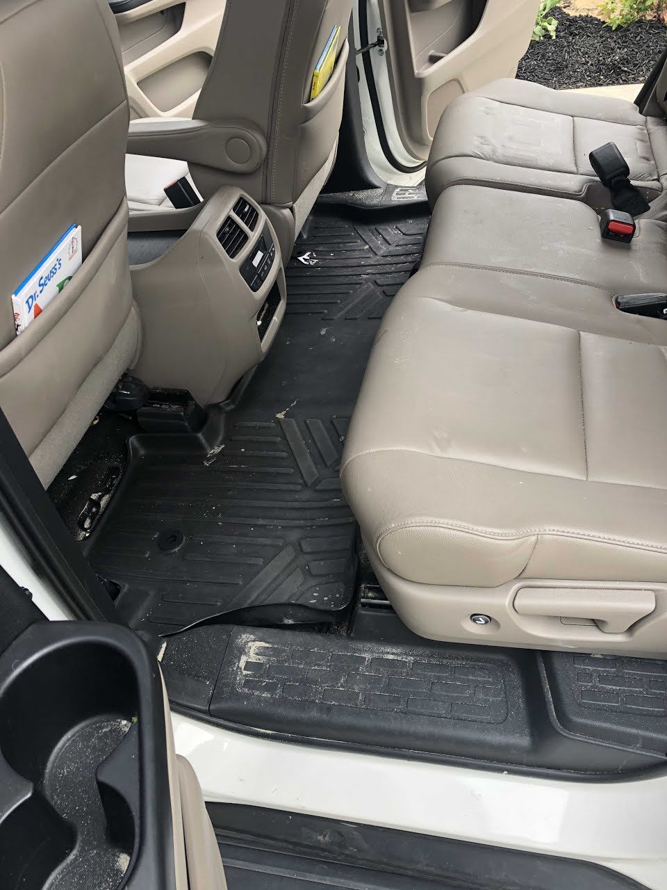 Honda Pilot back seat before an interior detail, covered in crumbs and debris