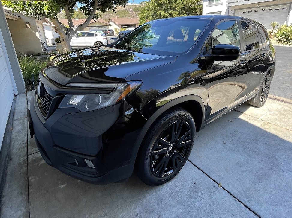 The same Honda Passport with mirror-gloss paint after a full exterior detail