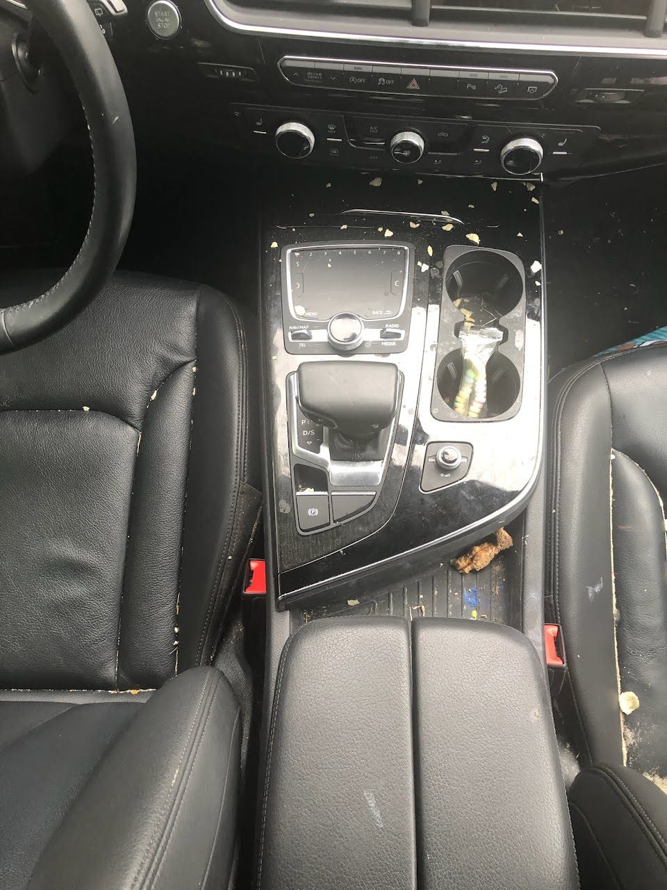 Center console and cupholders covered in crumbs before an interior detail in San Diego