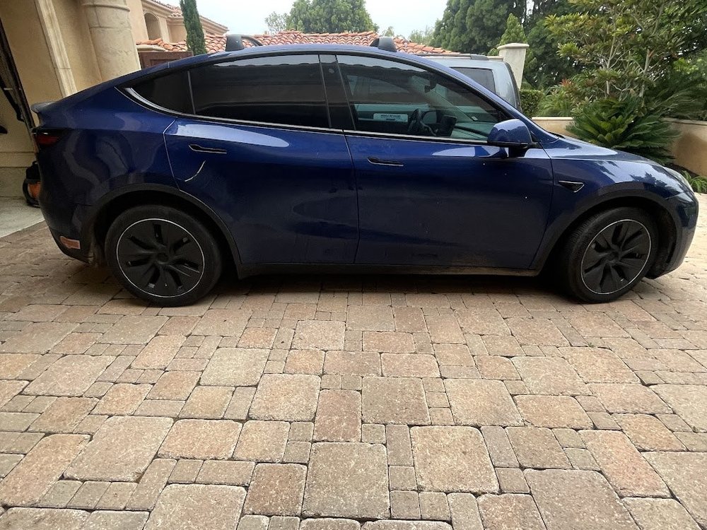 Tesla Model Y after a mobile detail, dark paint reflecting clean